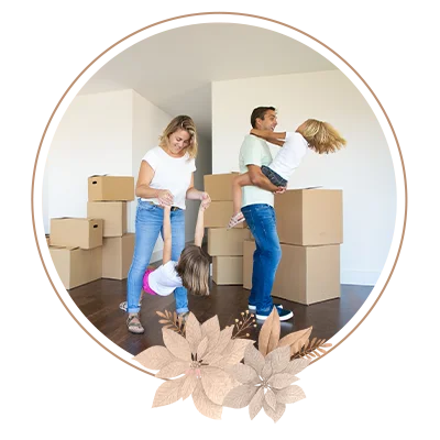 Parents and two girls carrying boxes into new empty flat together