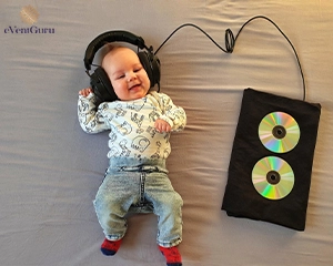 cute baby lying on bed with headphones on his head